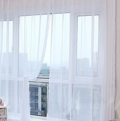 Close-up of a solid red sheer tulle curtain hanging in front of a window, allowing light to filter through. - Image 27