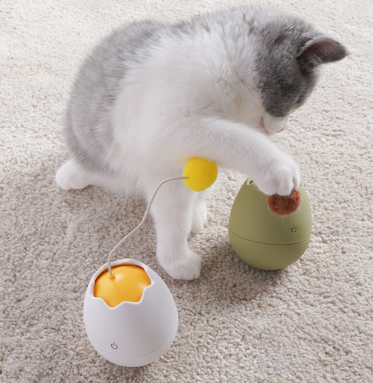 White egg-shaped automatic cat toy with a yellow interior and a flexible wire holding a yellow fuzzy ball. - Image 16