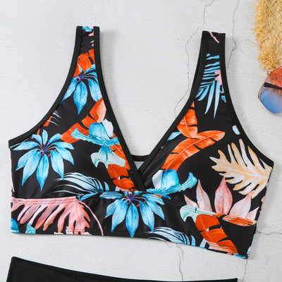 Two-piece swimsuit with a black background and vibrant pink and purple tropical floral print. Features a V-neck crop top and high-waisted boxer shorts. - Image 35