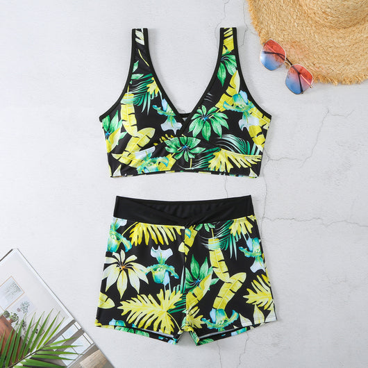 Two-piece swimsuit with a black background and vibrant pink and purple tropical floral print. Features a V-neck crop top and high-waisted boxer shorts. - Image 37