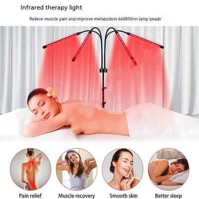 Red light therapy lamp with four adjustable arms illuminating a person lying on a white massage table. - Image 9
