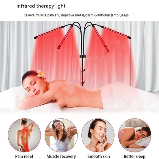 Red light therapy lamp with four adjustable arms illuminating a person lying on a white massage table. - Image 9