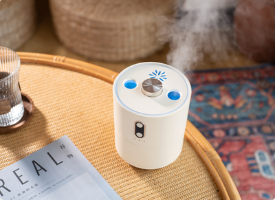 White volcanic flame aroma essential oil diffuser emitting orange light and mist on a wooden desk next to a laptop. - Image 15
