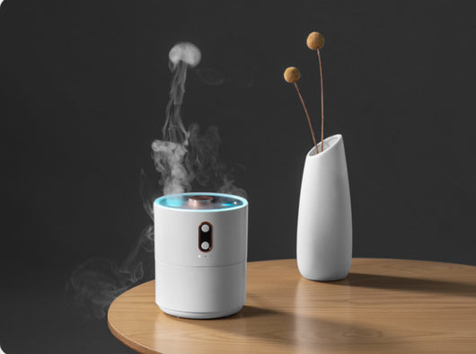 White volcanic flame aroma essential oil diffuser emitting orange light and mist on a wooden desk next to a laptop. - Image 16