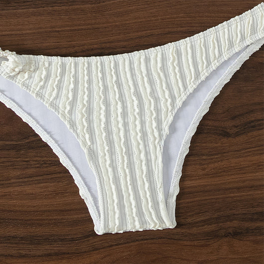 Women's white ribbed V-neck bikini with a front tie top and side ring bottoms, modeled by the ocean. - Image 7