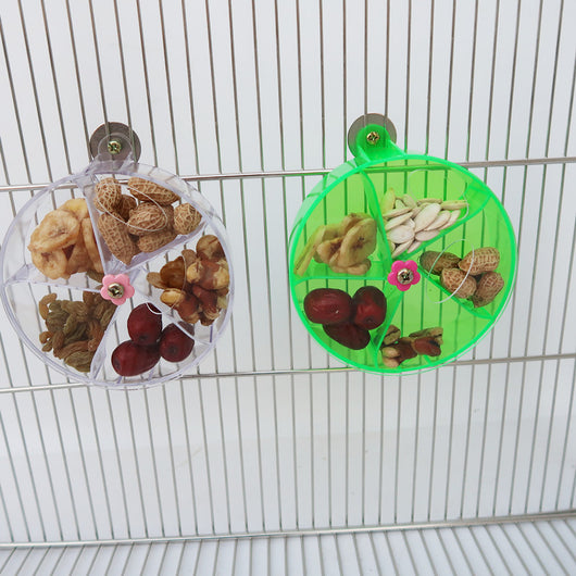 Clear acrylic bird foraging wind wheel toy with multiple compartments filled with nuts and dried fruit, attached to a bird cage. - Image 12