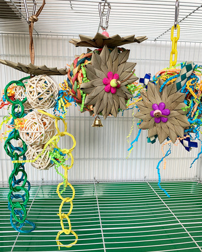 Colorful parrot chew toy made from natural fibers, featuring a woven ball, leaf-like accents, a bell, and a carabiner clip. - Image 16