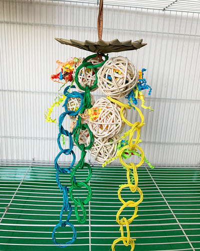 Colorful parrot chew toy made from natural fibers, featuring a woven ball, leaf-like accents, a bell, and a carabiner clip. - Image 17