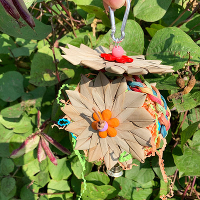 Colorful parrot chew toy made from natural fibers, featuring a woven ball, leaf-like accents, a bell, and a carabiner clip. - Image 19