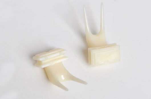 White plastic bird fruit fork clipped onto blue birdcage bars, designed to hold fruit or vegetables for pet birds. - Image 21