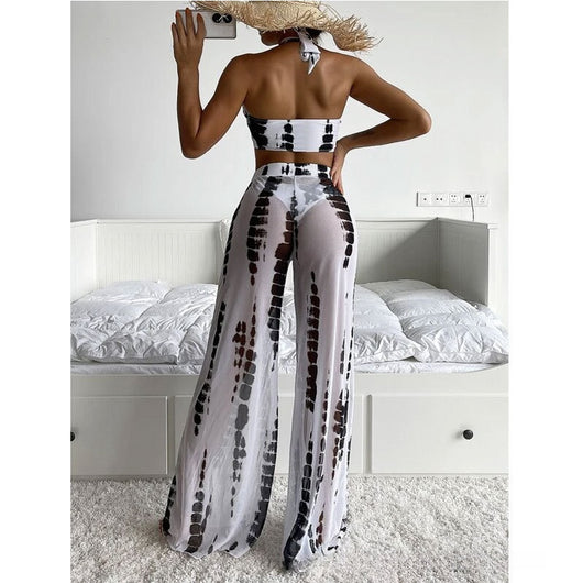 Woman in a white and blue tie-dye three-piece swimsuit set, featuring a halter bikini top, bottoms, and mesh cover-up pants. - Image 18