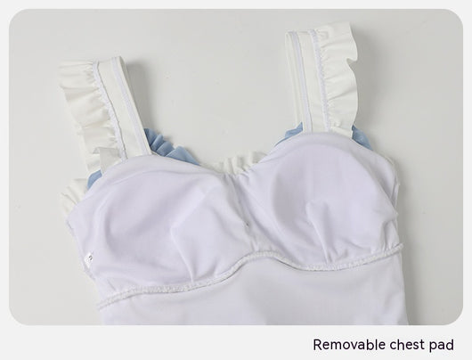 Women's white one-piece swimsuit with light blue lace-up sides, ruffled straps, and pearl-like buttons. - Image 16