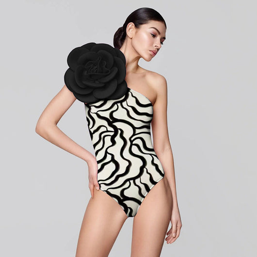 Black one-piece swimsuit with a large 3D flower on one shoulder and a geometric pattern on the bodice. - Image 37