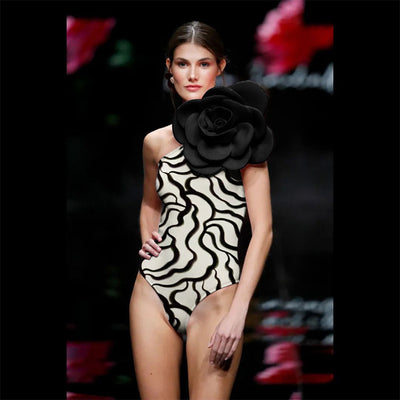 Black one-piece swimsuit with a large 3D flower on one shoulder and a geometric pattern on the bodice. - Image 48