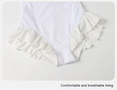 Women's white one-piece swimsuit with light blue lace-up sides, ruffled straps, and pearl-like buttons. - Image 30
