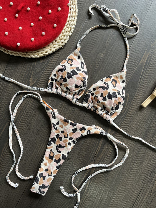 White textured bikini with red cherry print, featuring a triangle top and tie-side bottoms, on a woven mat. - Image 19