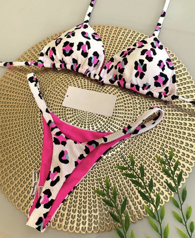 White textured bikini with red cherry print, featuring a triangle top and tie-side bottoms, on a woven mat. - Image 21