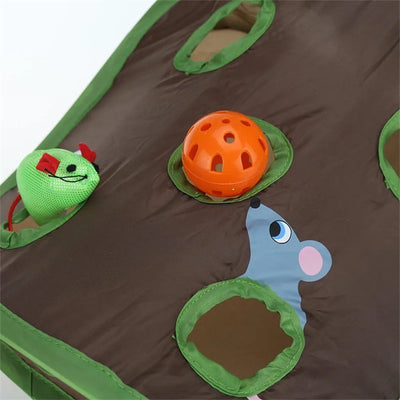 Grey tabby kitten playing with a brown and green hide-and-seek cat toy with multiple holes and a mouse graphic. - Image 12