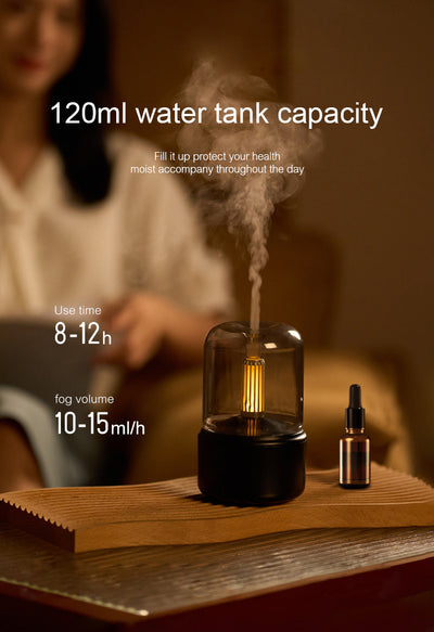 White cylindrical aroma diffuser with a clear top and an amber candlelight-effect LED light. - Image 16