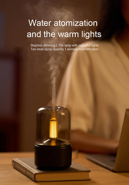 White cylindrical aroma diffuser with a clear top and an amber candlelight-effect LED light. - Image 21