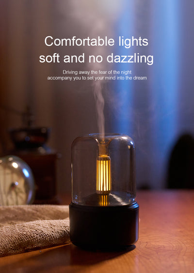 White cylindrical aroma diffuser with a clear top and an amber candlelight-effect LED light. - Image 23