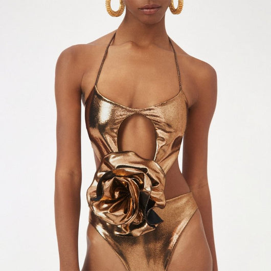 Metallic bronze one-piece swimsuit with a one-shoulder design, large decorative flower, and side cut-out revealing a black panel. - Image 18