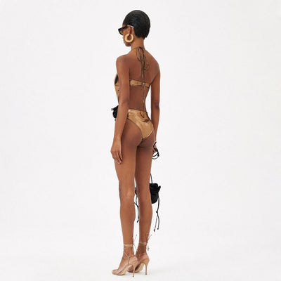 Metallic bronze one-piece swimsuit with a one-shoulder design, large decorative flower, and side cut-out revealing a black panel. - Image 19