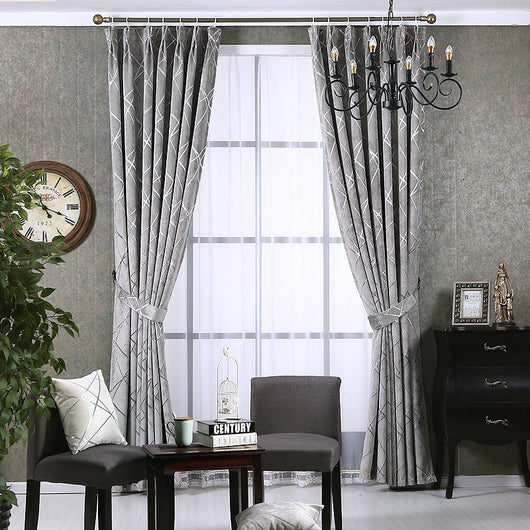 Gray chenille blackout curtains with a subtle silver geometric pattern, hung on a gold rod in a modern living room. - Image 9