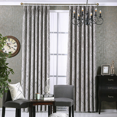 Gray chenille blackout curtains with a subtle silver geometric pattern, hung on a gold rod in a modern living room. - Image 10