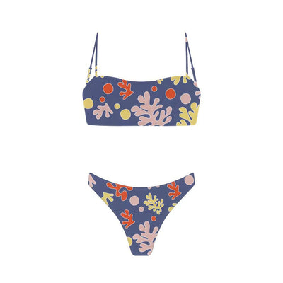 Woman in a blue banded bikini with a circular pattern standing on a sandy beach with clear water and green hills. - Image 32