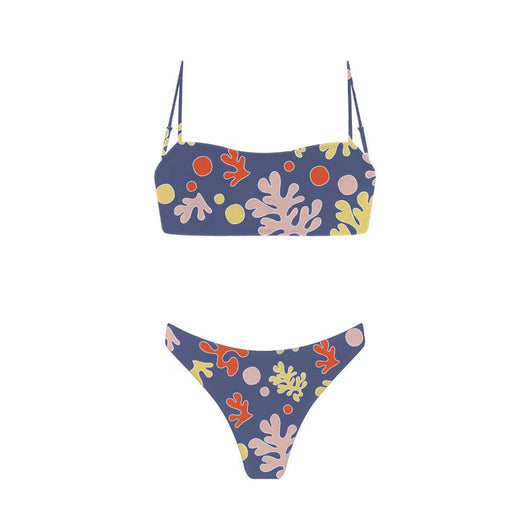 Woman in a blue banded bikini with a circular pattern standing on a sandy beach with clear water and green hills. - Image 32