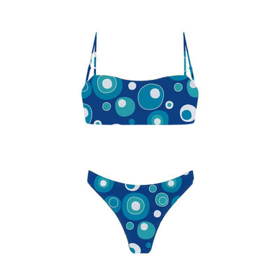 Woman in a blue banded bikini with a circular pattern standing on a sandy beach with clear water and green hills. - Image 33