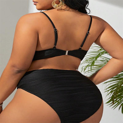 Plus size woman in a black textured two-piece bikini with gold V-shaped hardware. The top is a plunge style, and the bottoms are high-waisted. - Image 17