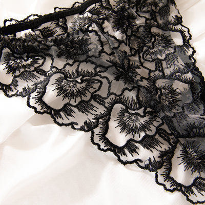 Black embroidered lace bra and thong set with transparent design and steel ring, displayed on white fabric. - Image 17