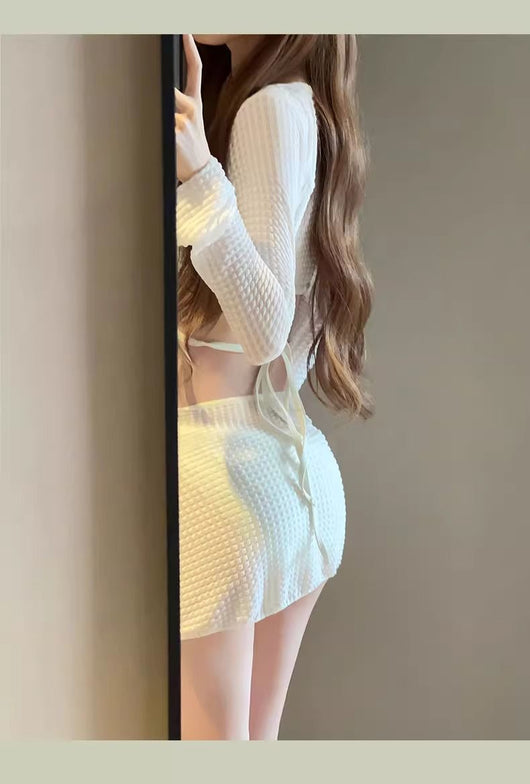 White three-piece bikini swimsuit set with a long-sleeve crop top, bikini top with gold ring, and ruched mini skirt. - Image 26