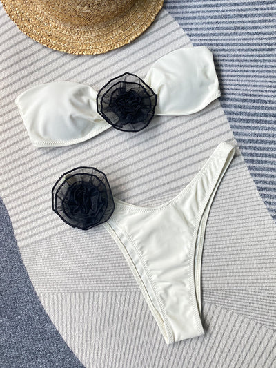 Black tube top bikini with white three-dimensional flower embellishments, worn by a woman partially submerged in water. - Image 26