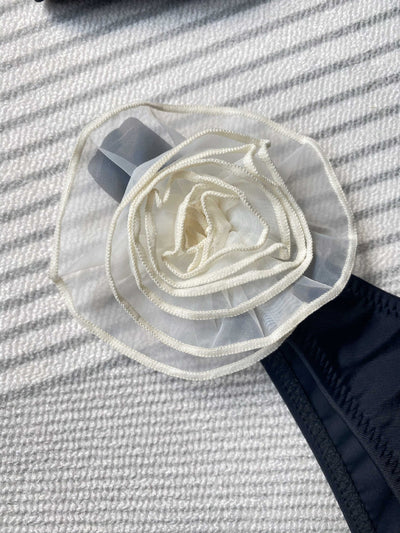 Black tube top bikini with white three-dimensional flower embellishments, worn by a woman partially submerged in water. - Image 27