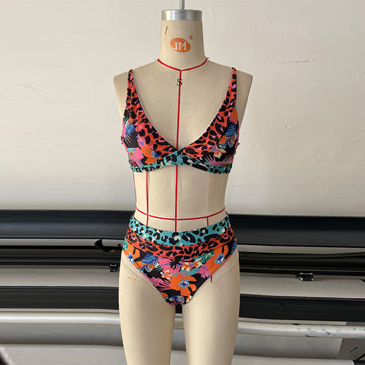 Women's high-waisted bikini with a vibrant floral and leopard print in blue, orange, and green, at the beach. - Image 16