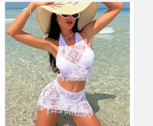 Woman wearing a black lace two-piece beach cover-up with a halter crop top and mini tassel skirt on a sunny beach. - Image 12