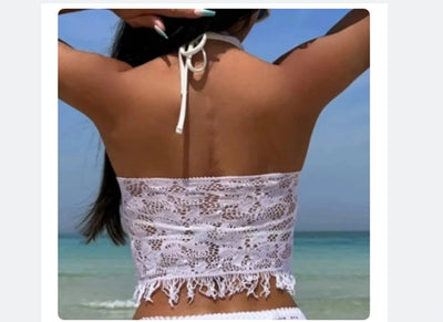 Woman wearing a black lace two-piece beach cover-up with a halter crop top and mini tassel skirt on a sunny beach. - Image 13
