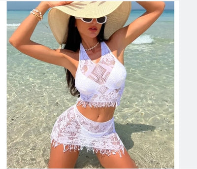 Woman wearing a black lace two-piece beach cover-up with a halter crop top and mini tassel skirt on a sunny beach. - Image 15