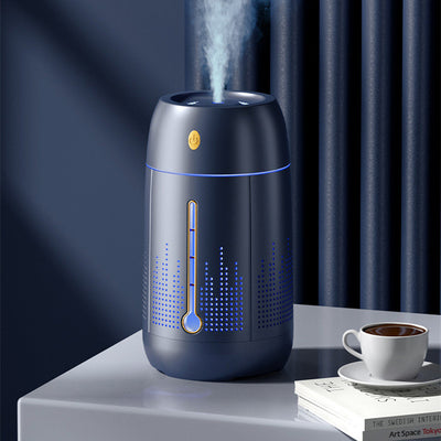 White cylindrical household humidifier with a visible water level indicator, next to its brown cardboard packaging.
