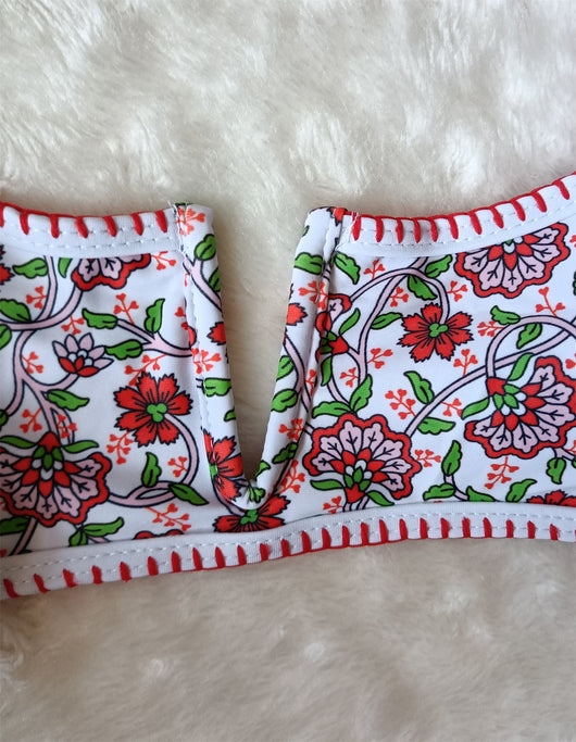 White two-piece swimsuit with red and green floral print, V-neck top, criss-cross straps, and high-cut bottoms. - Image 9