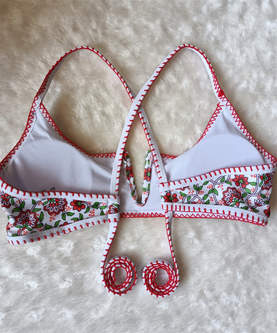 White two-piece swimsuit with red and green floral print, V-neck top, criss-cross straps, and high-cut bottoms. - Image 10