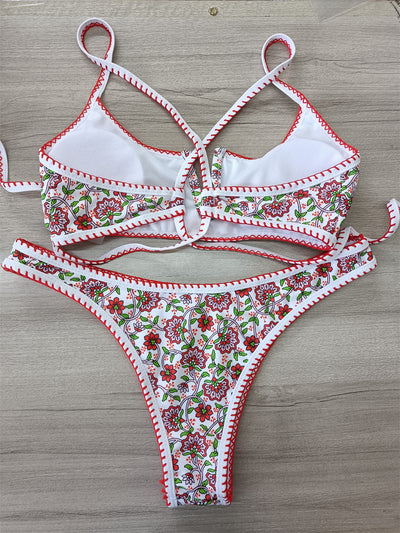 White two-piece swimsuit with red and green floral print, V-neck top, criss-cross straps, and high-cut bottoms. - Image 11