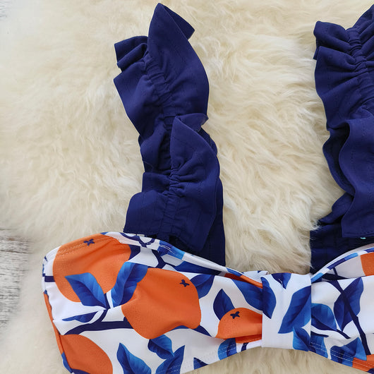 Women's high-waisted bikini swimsuit with orange and blue leaf print, ruffled navy blue straps, and a tie-front belt. - Image 8