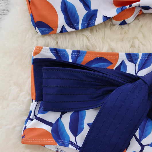 Women's high-waisted bikini swimsuit with orange and blue leaf print, ruffled navy blue straps, and a tie-front belt. - Image 12
