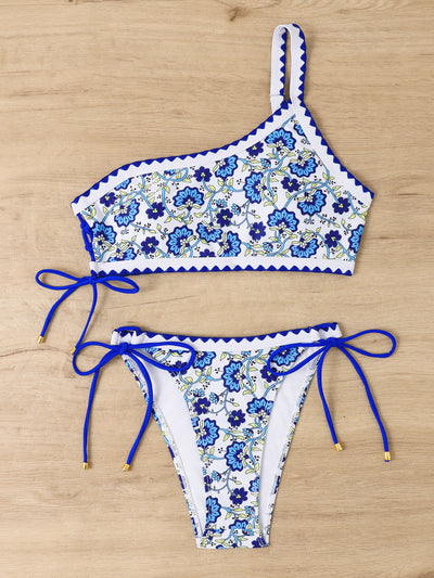 Women's one-shoulder bikini with red and blue floral print on white, featuring red trim and tie-side bottoms. - Image 33