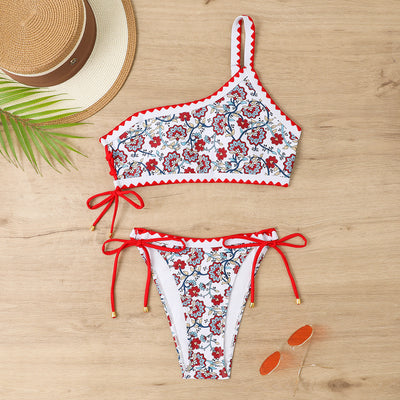 Women's one-shoulder bikini with red and blue floral print on white, featuring red trim and tie-side bottoms. - Image 37