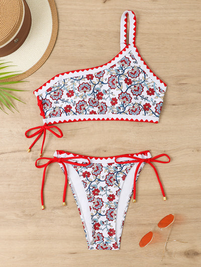 Women's one-shoulder bikini with red and blue floral print on white, featuring red trim and tie-side bottoms. - Image 39